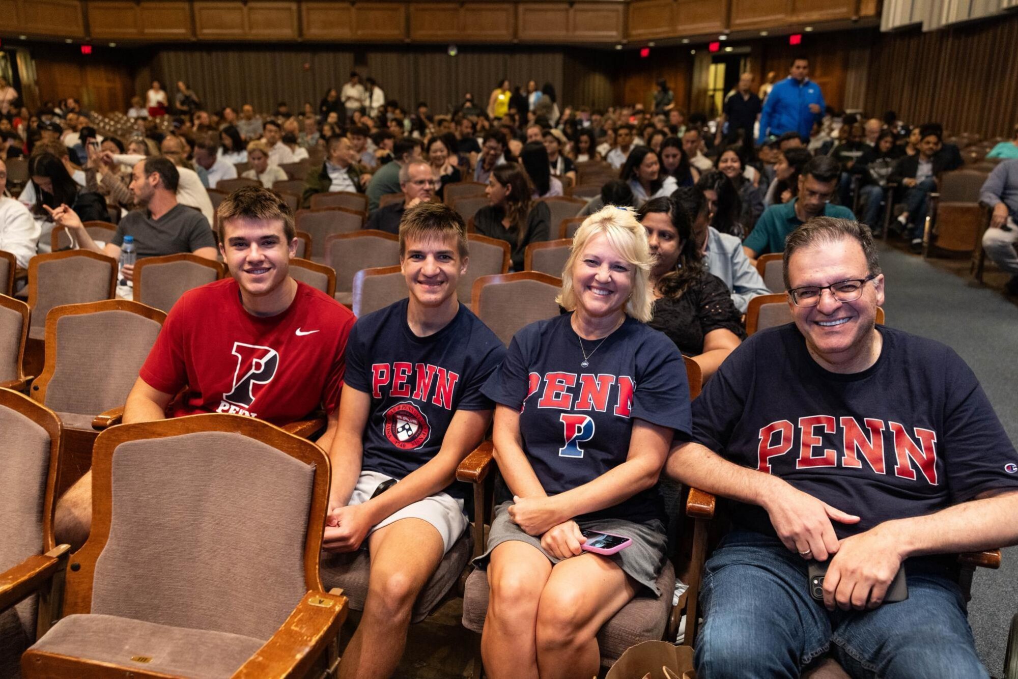 A four-person family in the audience all wearing Penn T-shirts.