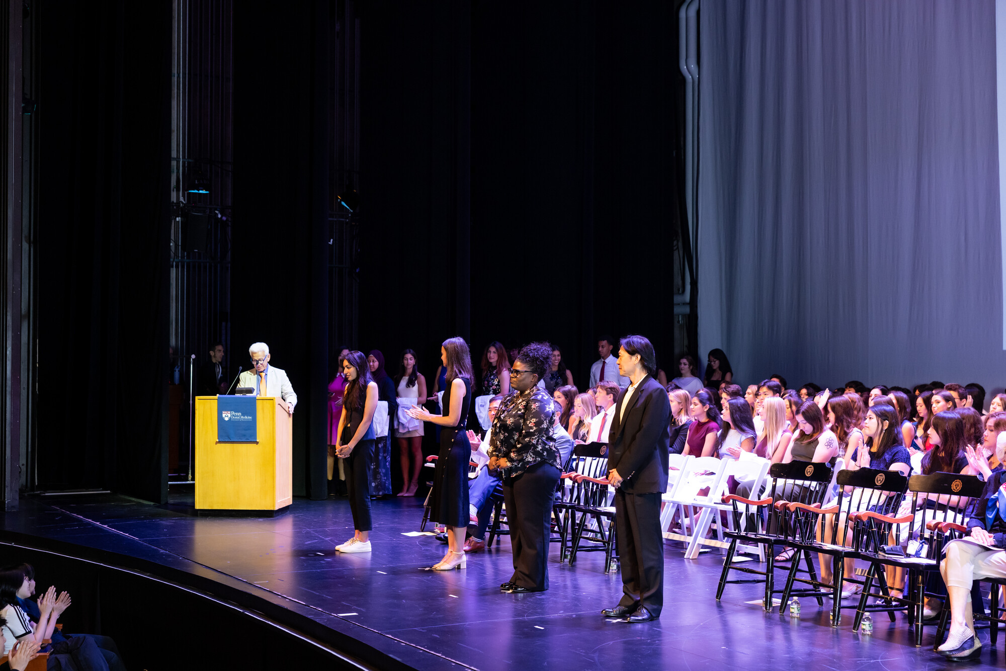 Dean Mark Wolff speaking at the podium onstage at Penn Dental’s white coat ceremony.
