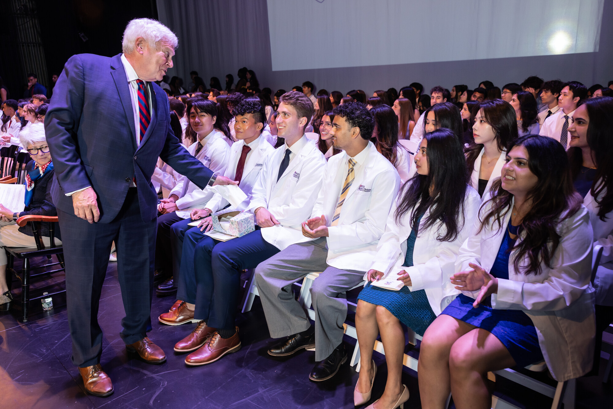 Dean Mark Wolff speaking with students onstage at Penn Dental’s white coat ceremony.