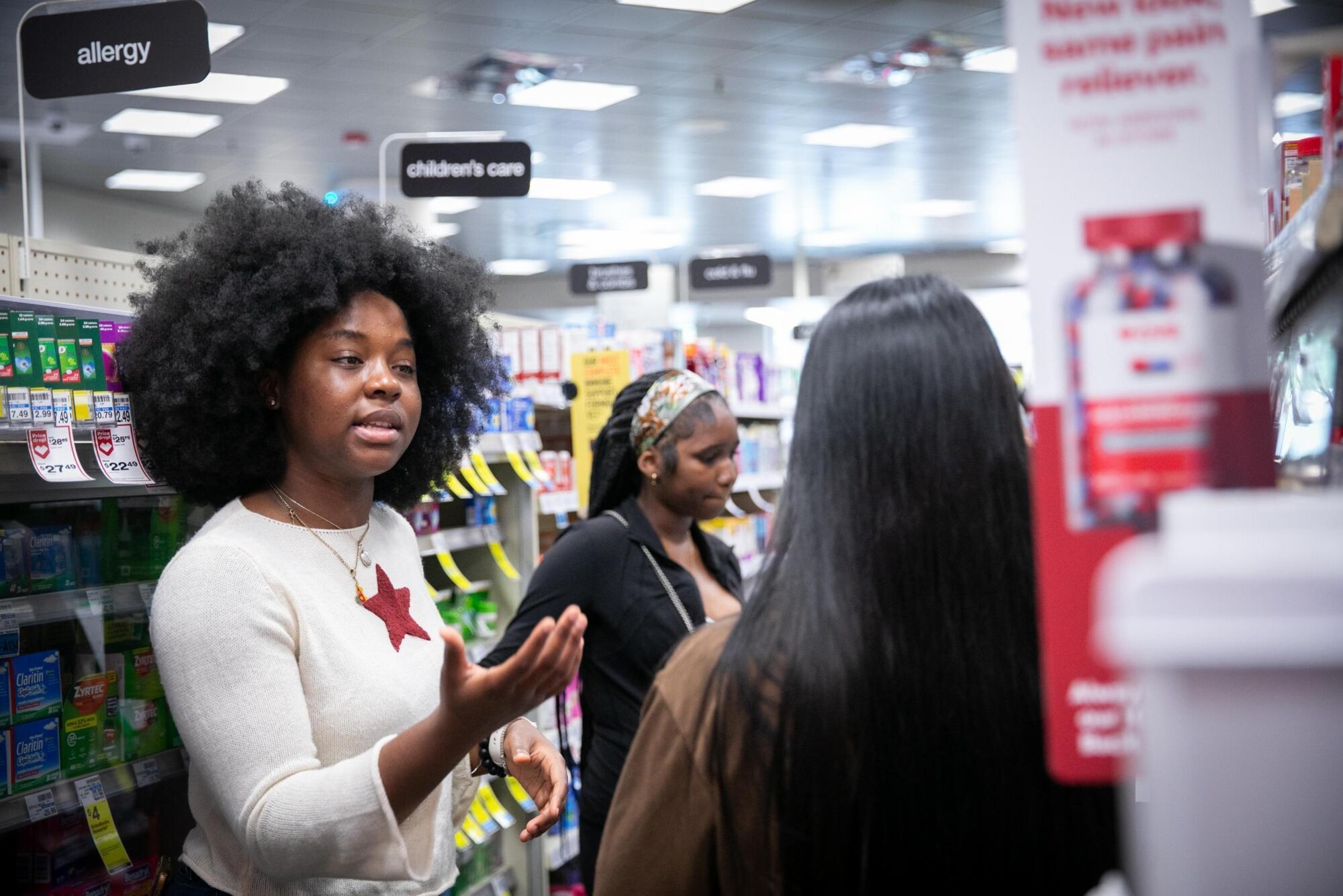 High school students taking notes in the aisle at CVS.