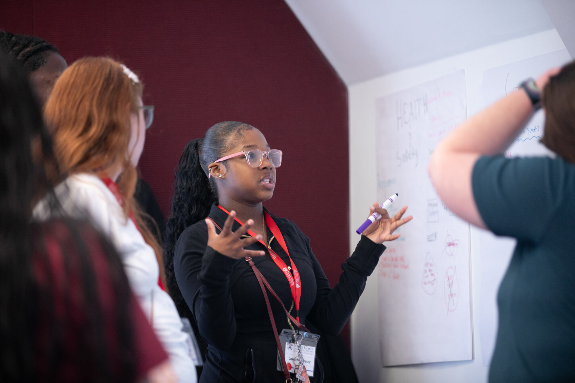 High school students talking at a white board.