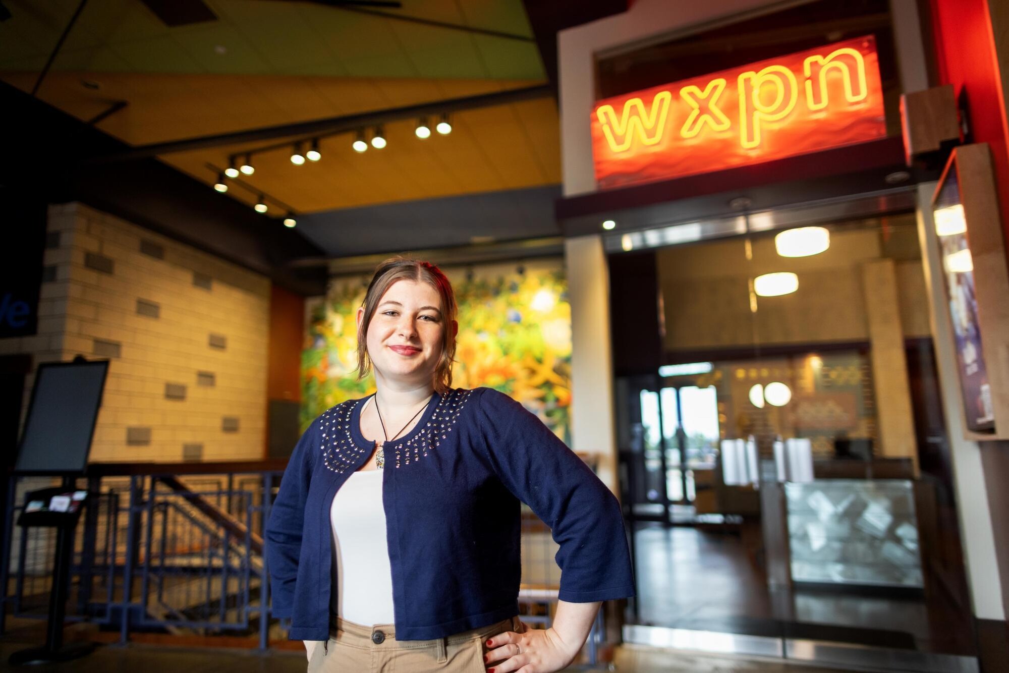 Luiza Sulea standing in front of neon WXPN sign