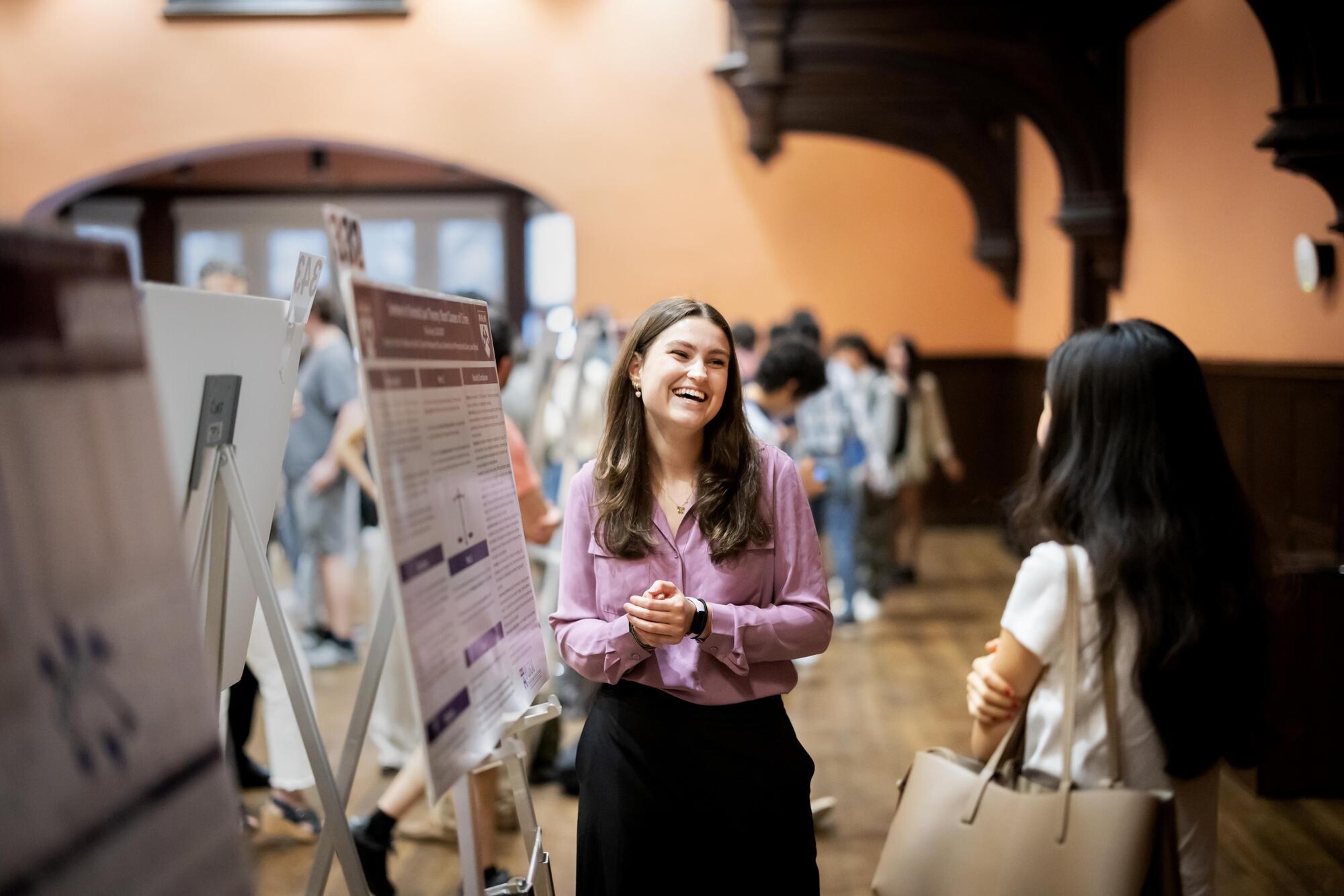 A student stands by their poster at the CURF Poster Expo in Houston Hall.
