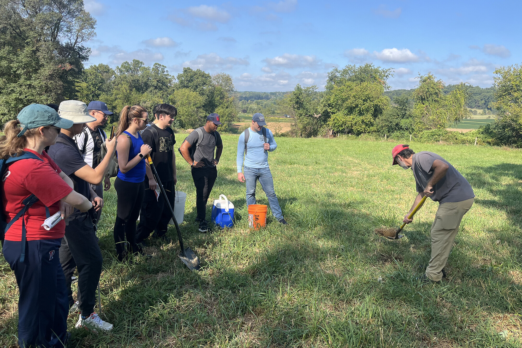 Students digging in a field to get soil samples.