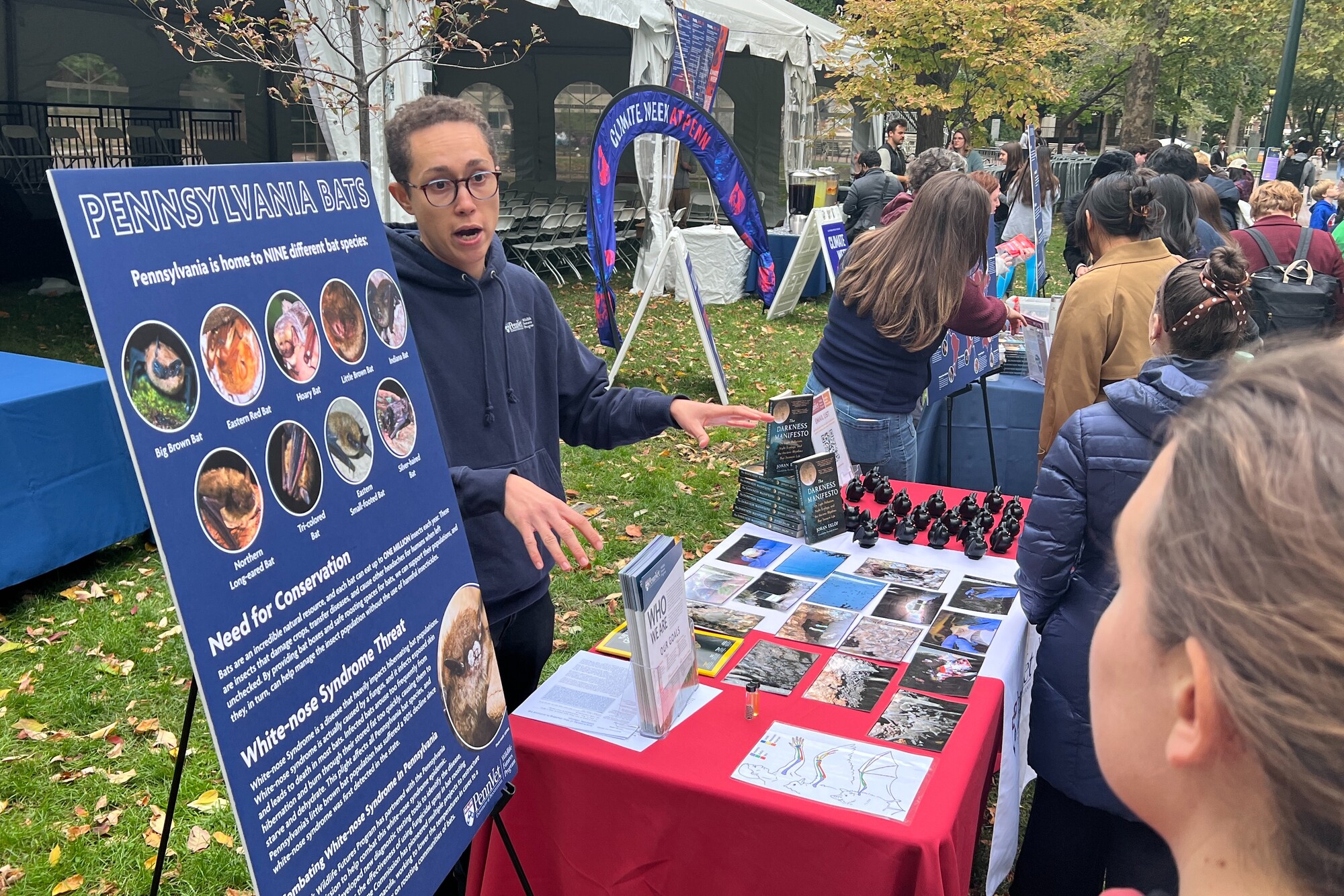A person discussing Pennsylvania bats with visitors at a table during Penn’s Climate Week.