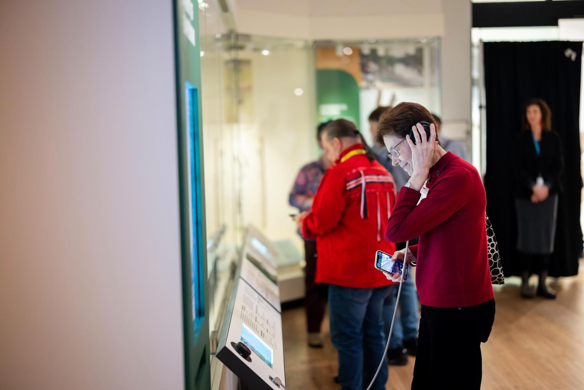 A. person using headphones to listen to info in Penn’s new Native North American Gallery.
