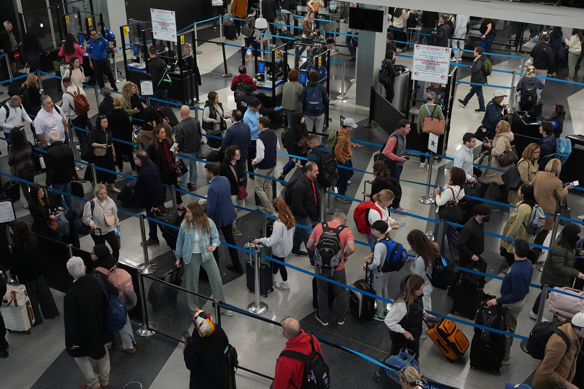 Travelers in a busy security checkpoint at an airport.
