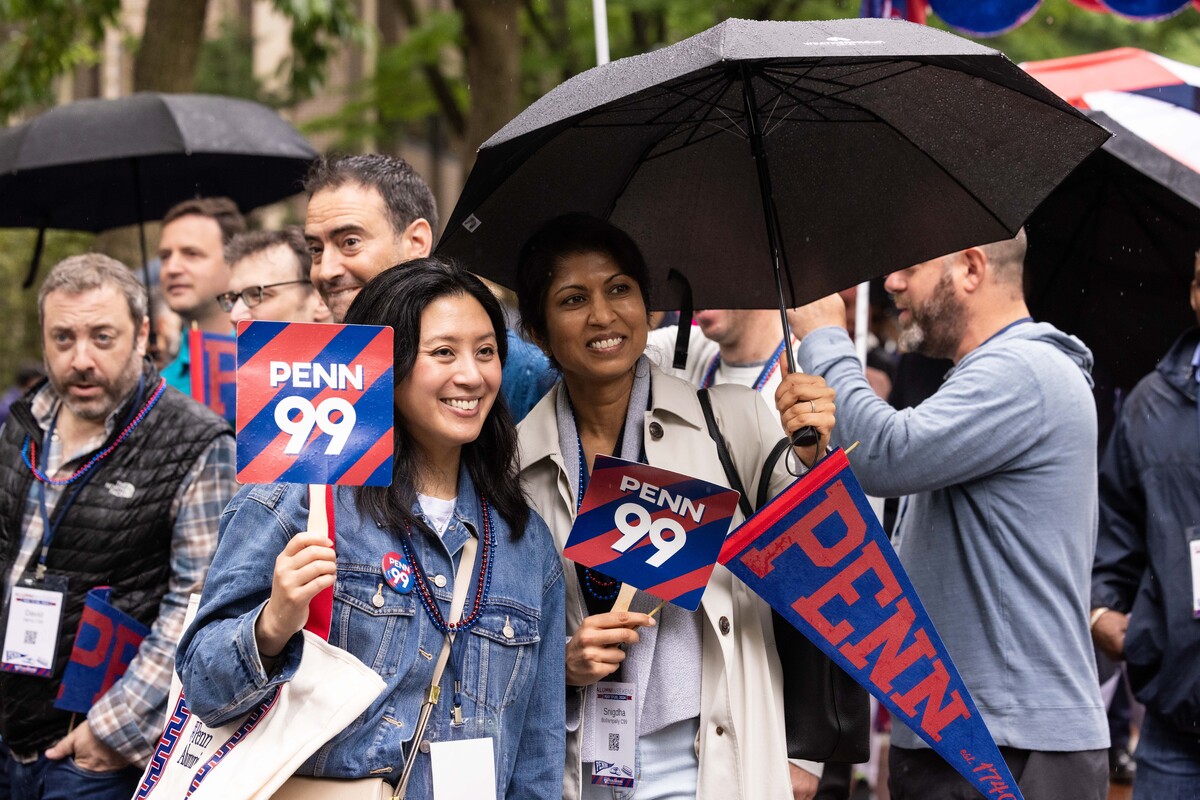 alumni hold Penn '99 signs and umbrella for Alumni Parade