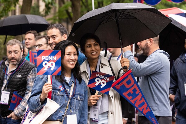 alumni hold Penn '99 signs and umbrella for Alumni Parade