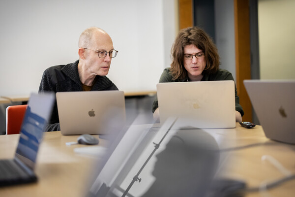 two people looking at laptop computers 