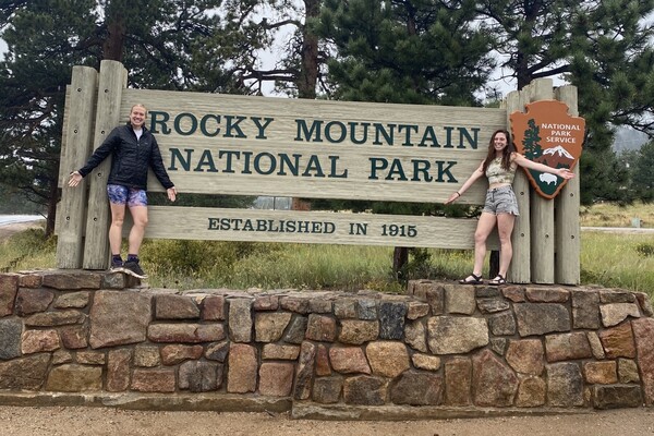 Brianna Blunk and Natalie Bauer in front of Rocky Mountain National Park sign.