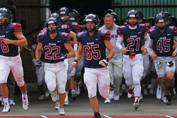 Sprint football players run onto the field.