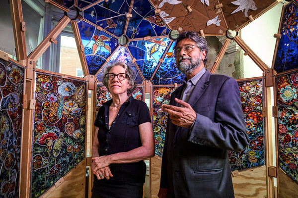 Judith Schaechter and Anjan Chatterjee looking at her stained glass installation.