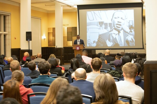 Eddie Glaude addresses the crowd with a large image of MLK in the background