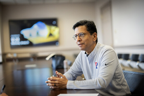 Ramanan Raghavendran engages in conversation at a conference table. 