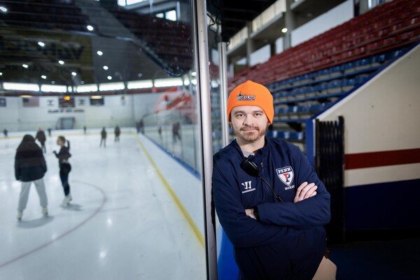 Mike Petrocelli leans against the glass at the Penn Rice Rink.