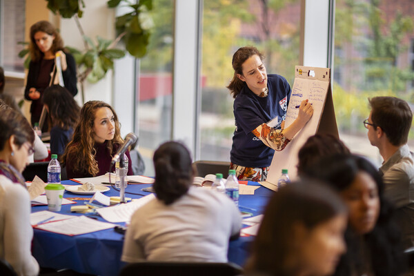 Laurel Redding of the School of Veterinary Medicine writes on an easel as members of her table look on