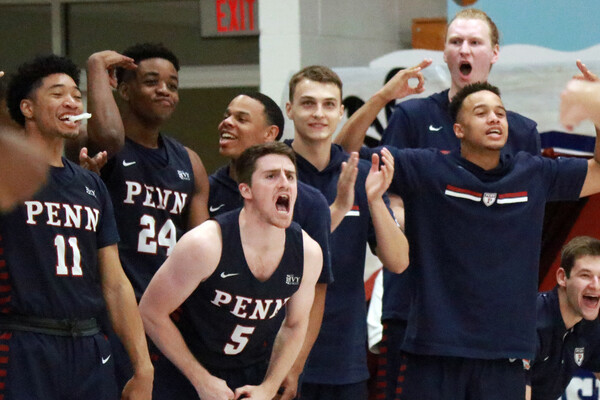 Penn basketball players cheer on their teammates on the sidelines