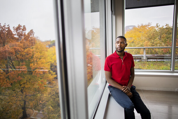 JD Goins sits near a window, looking out onto the beautiful fall colors on the Penn campus' trees.