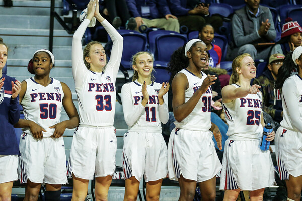 The women's basketball team starters cheer on the teammates from the bench in the Palestra
