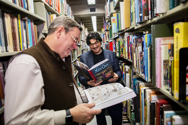 Robert Berry and JC Cloutier read comics in Van Pelt-Dietrich Library 