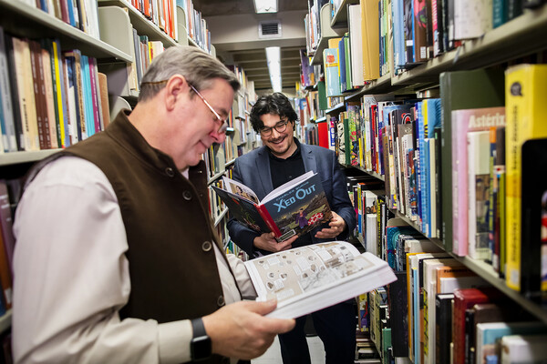 Robert Berry and JC Cloutier read comics in Van Pelt-Dietrich Library