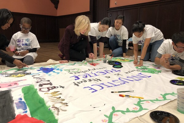 Amy Gutmann painting banners with children