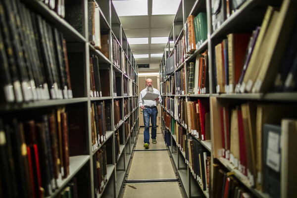 library archivist walking through book stacks