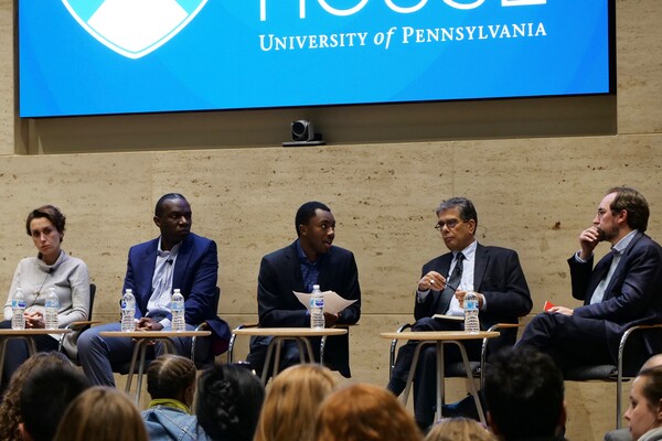 Six people sitting on a stage during discussion.