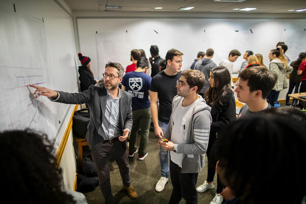 Penn history professor Brent Cebul working with students on wall maps. 