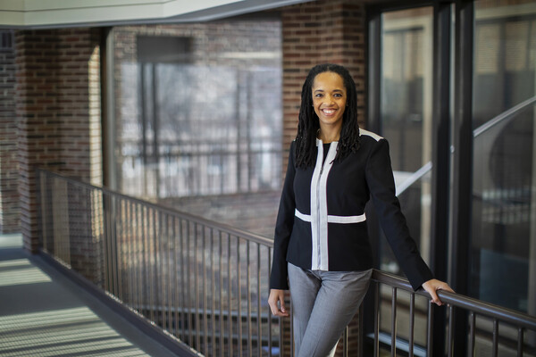 Stephanie Creary of Wharton poses along a railing in Steinberg Hall-Dietrich Hall.