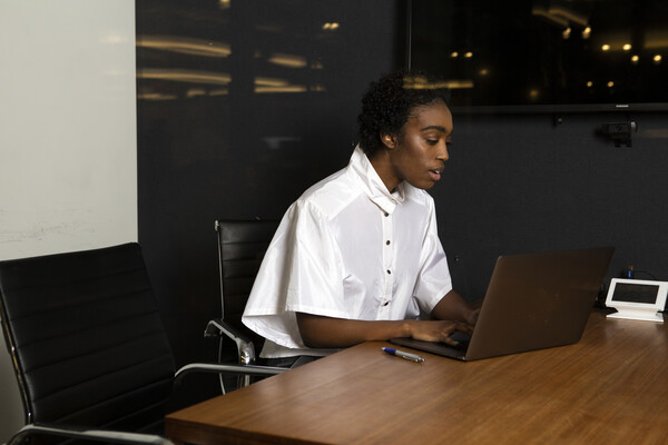 A non-binary person using a laptop at work.