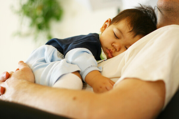 infant sleeping on parent's chest