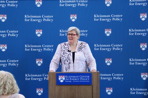 Rachel Kyte stands at a podium speaking, the sign on the podium reads "Kleinman Center for Energy Policy."