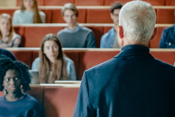 person facing a classroom auditorium with back to camera