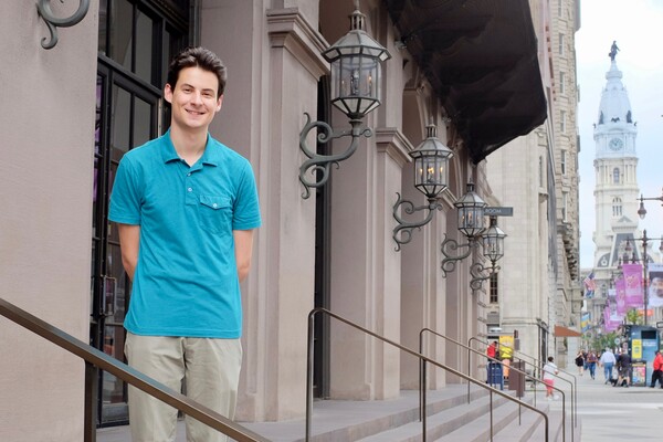 Student standing on steps of the Academy of Music in Philadelphia.