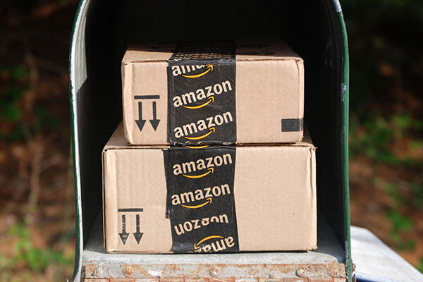 Two Amazon boxes inside a mailbox outside in daylight