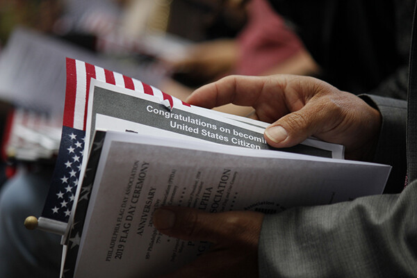 closeup of new citizen handbook and a flag in the hands of a new U.S. citizen