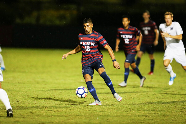 Joey Bhangdia, a midfielder on the men's soccer team, dribbles the ball down the field.