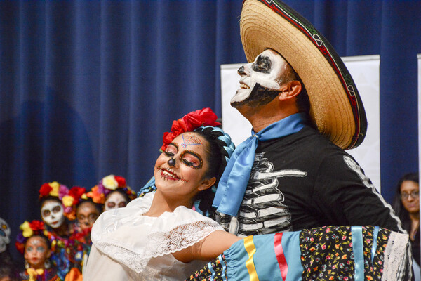 Two costumed dancers at a Dia de Los Muertos event