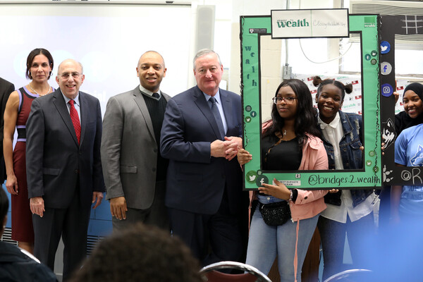 Four adults and three high school students posed with social media frames 