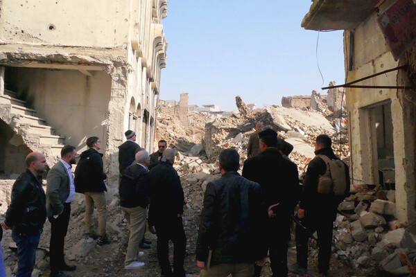 people gathered around surveying iraqi destruction