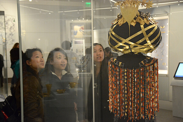 Students examine Queen Puabi's Haddress through glass case