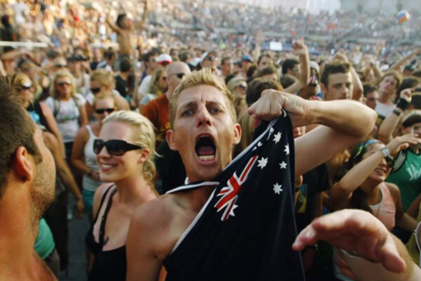 Australian person shouts while gripping flag shirt