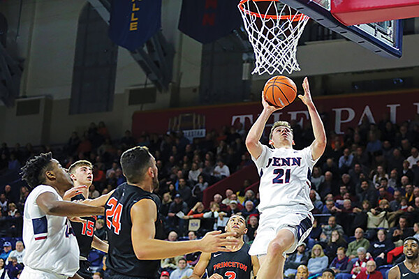Number 21 player Ryan Betley makes a shot on court during a Penn basketball game.