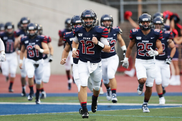 Quarterback Eddie Jenkins runs onto the field with his teammates at Franklin Field.