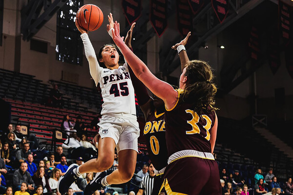 Suspending in the air against Iona at the Palestra, freshman Kayla Padilla shoots the ball between to opponents.