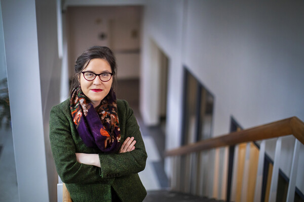 A person standing with arms crossed on a stairwell. 