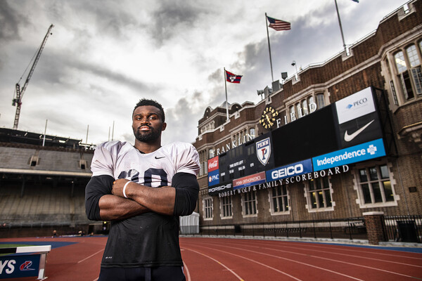 In his shoulder pads, Karekin Brooks of the Penn football team poses with his arms folded on the track at Franklin Field.