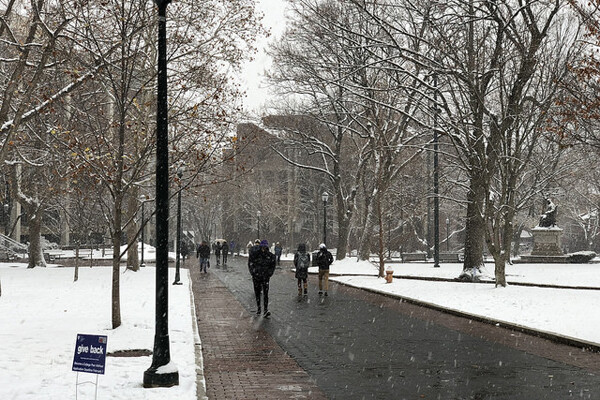 Snowfall on Locust Walk with small Give Back sign on lawn